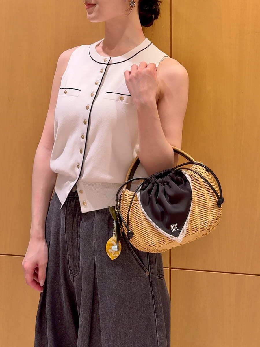 ブラック系のかごバッグ、ブラック系のデニムパンツ、ホワイト系のニット/セーターを着用したレディースの夏コーディネートの6枚目の写真