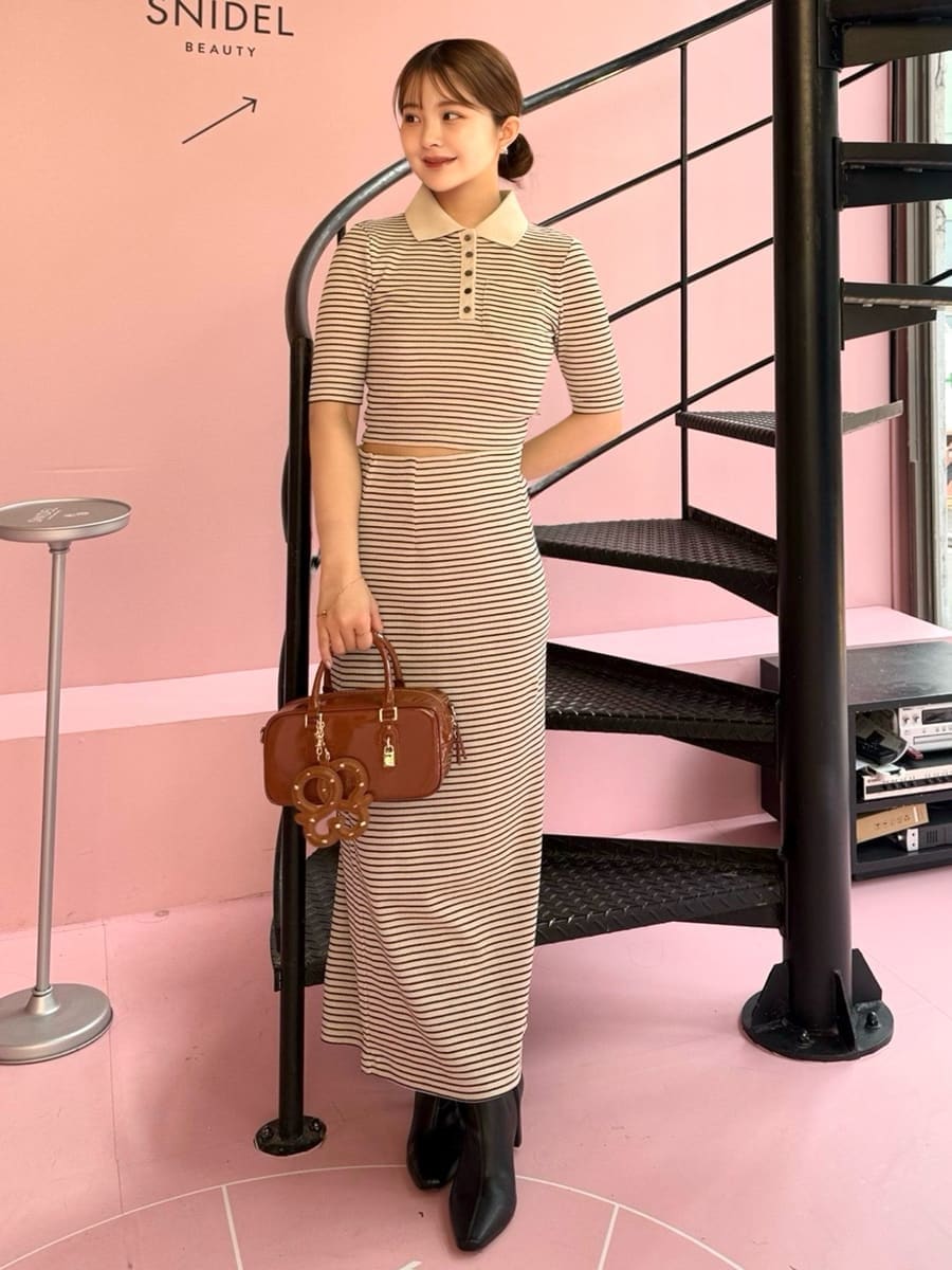 ホワイト系のワンピース、ブラック系のブーツ、ブラウン系のボストンバッグを着用したレディースの秋コーディネートの4枚目の写真