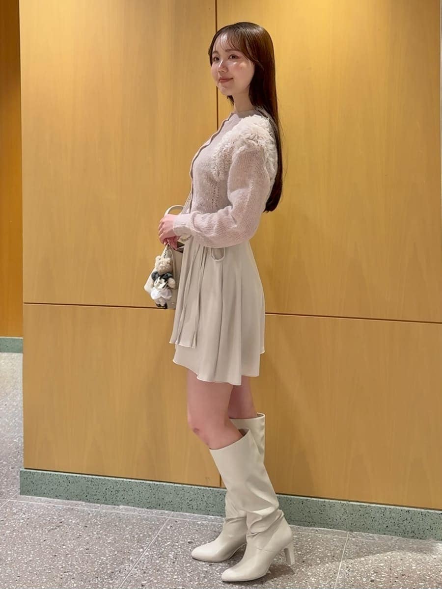 ホワイト系のその他パンツ、ピンク系のカーディガン/ボレロ、ホワイト系のブーツを着用したレディースの冬コーディネートの3枚目の写真