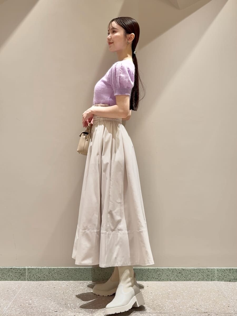 パープル系のニット/セーター、ホワイト系のスカート、ベージュ系のショルダーバッグを着用したレディースの夏コーディネートの2枚目の写真