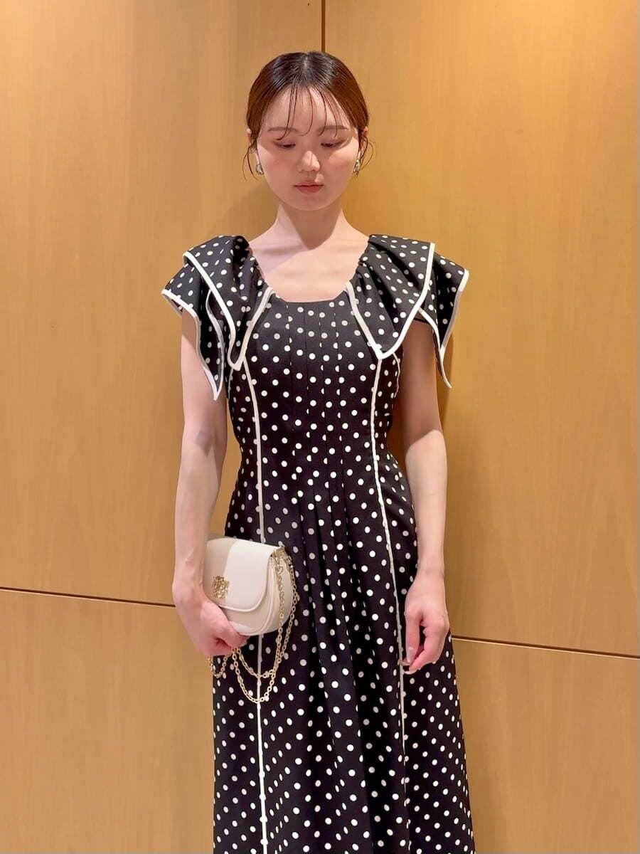 ブラック系のワンピース、ホワイト系のショルダーバッグを着用したレディースの春コーディネートの4枚目の写真