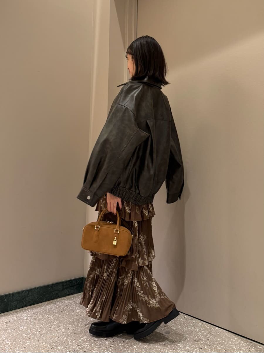 ブラウン系のワンピース、ブラウン系のブルゾン、イエロー系のボストンバッグを着用したレディースの秋コーディネートの3枚目の写真