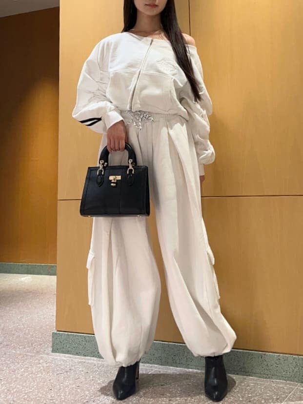 ホワイト系のスウェットパンツ、ホワイト系のスウェット、ブラック系のハンドバッグを着用したレディースの冬コーディネートの3枚目の写真