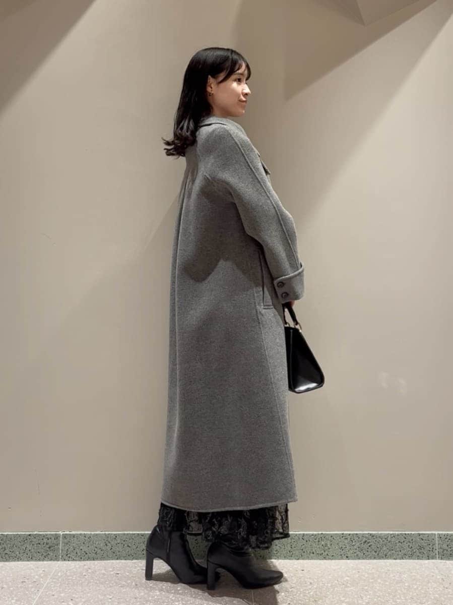 ブラック系のブーツ、グレー系のチェスターコート、ブラック系のスカートを着用したレディースの冬コーディネートの5枚目の写真