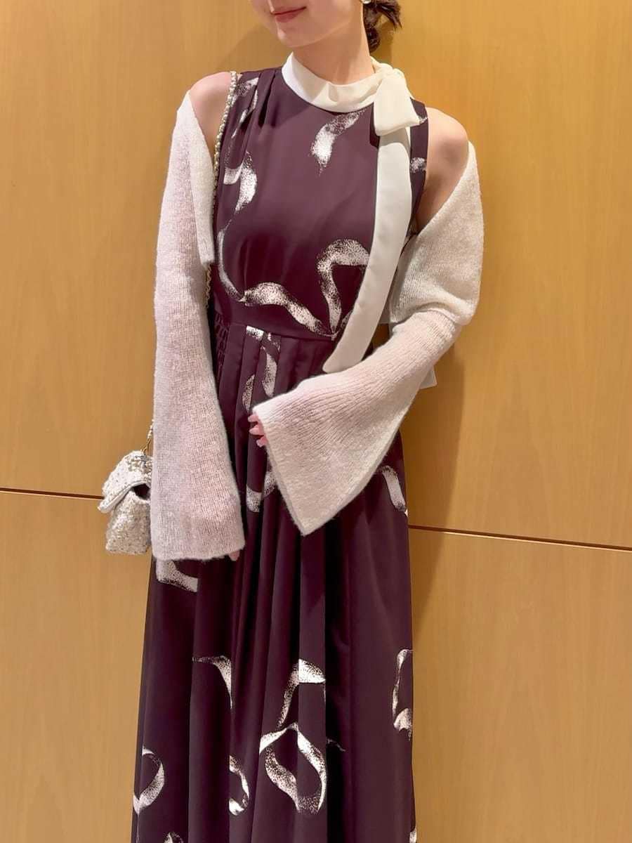 ホワイト系のショルダーバッグ、ブラウン系のワンピース、シルバー系のピアス（両耳用）を着用したレディースの冬コーディネートの6枚目の写真