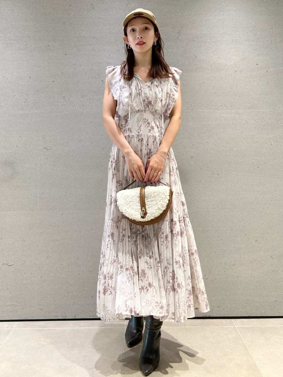 ピンク系のワンピース、イエロー系のハンドバッグ、グレー系のブーツを着用したレディースの秋コーディネートの6枚目の写真