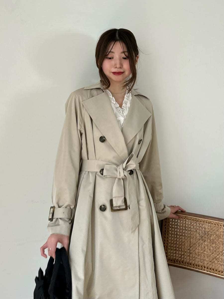 ブラック系のブーツ、ホワイト系のその他トップス、ベージュ系のトレンチコートを着用したレディースの春コーディネートの10枚目の写真
