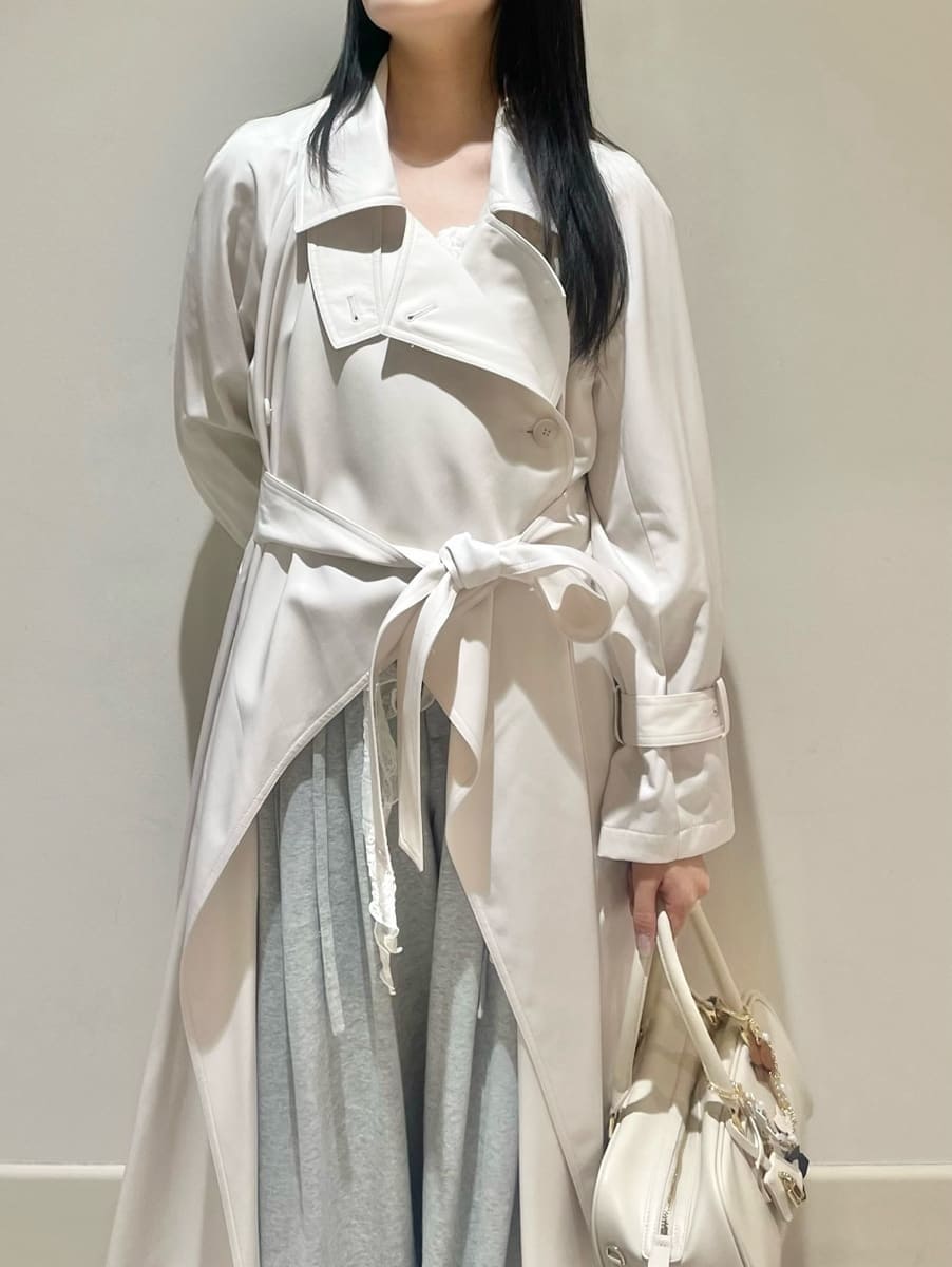 ブラック系のブーツ、ホワイト系のトレンチコート、グレー系のその他パンツを着用したレディースの冬コーディネートの6枚目の写真