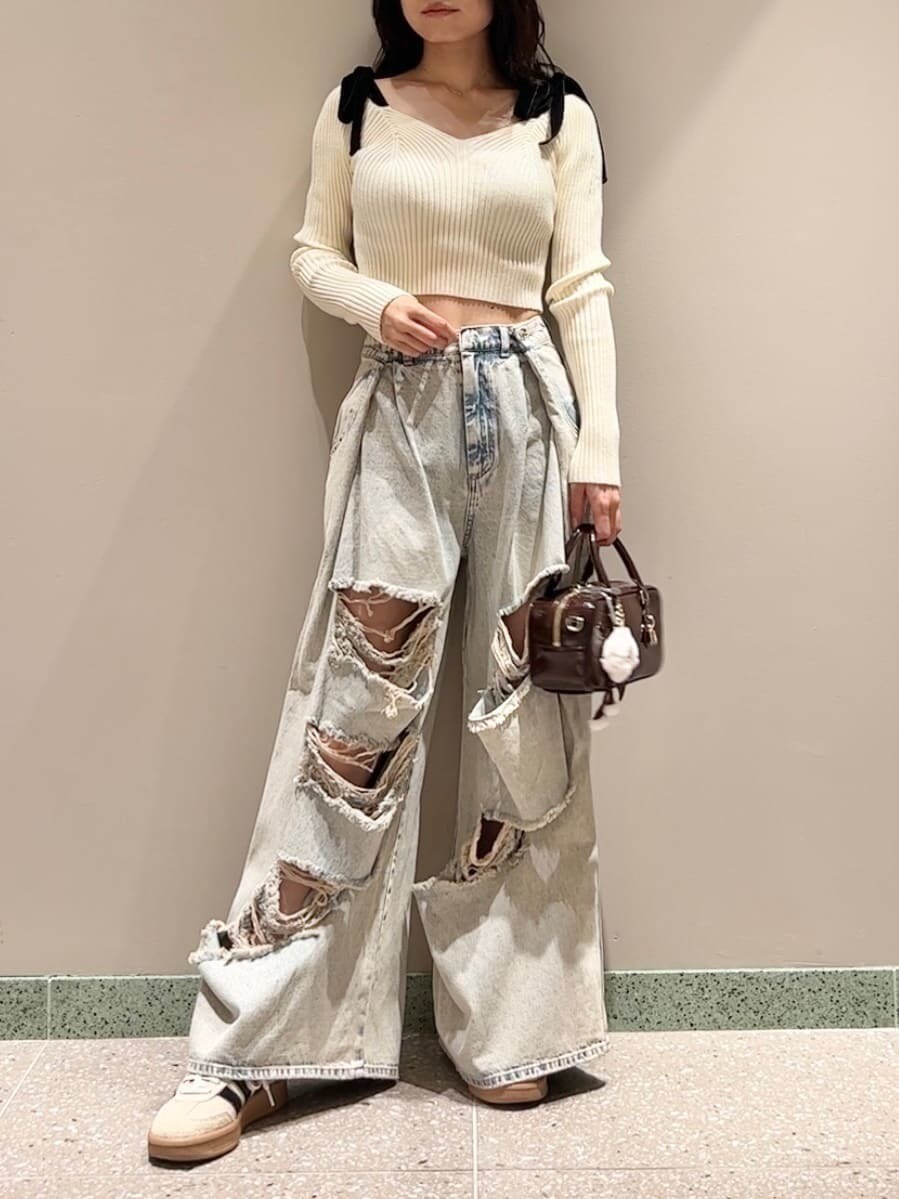 ホワイト系のニット/セーター、ブルー系のデニムパンツ、ブラウン系のボストンバッグを着用したレディースの秋コーディネートの2枚目の写真