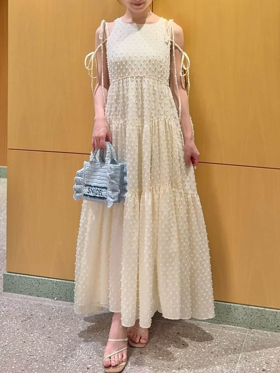 ブルー系のショルダーバッグ、ホワイト系のワンピース、その他のサンダルを着用したレディースの夏コーディネートの4枚目の写真