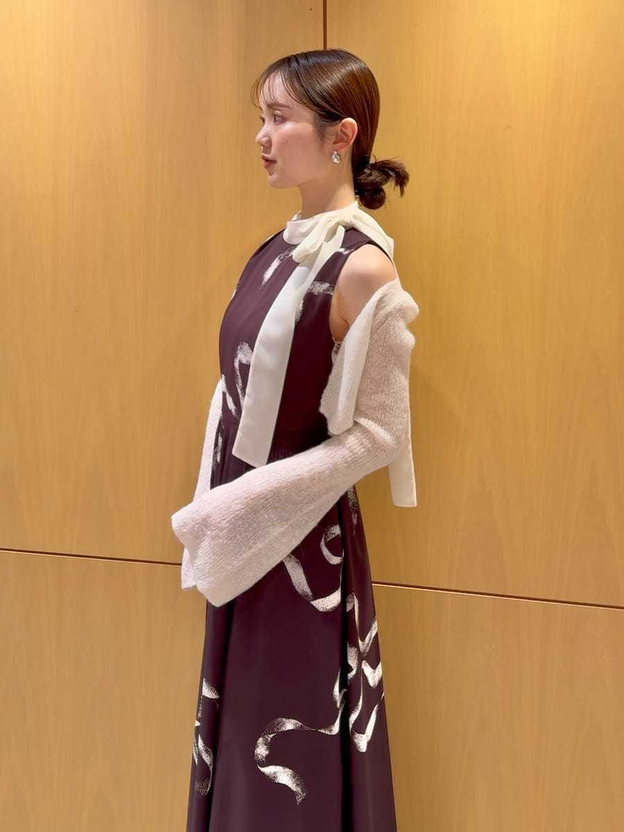 ホワイト系のショルダーバッグ、ブラウン系のワンピース、シルバー系のピアス（両耳用）を着用したレディースの冬コーディネートの7枚目の写真