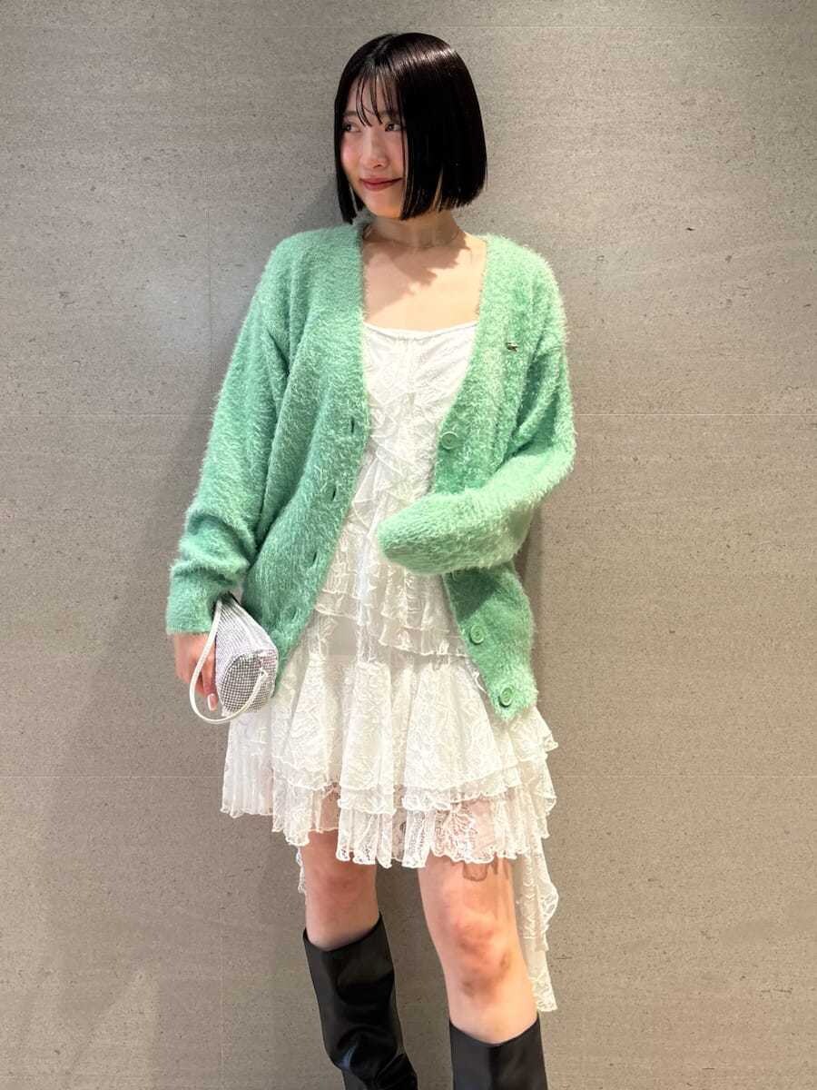 ホワイト系のワンピース、グリーン系のカーディガン/ボレロ、ブラック系のブーツを着用したレディースの冬コーディネートの3枚目の写真