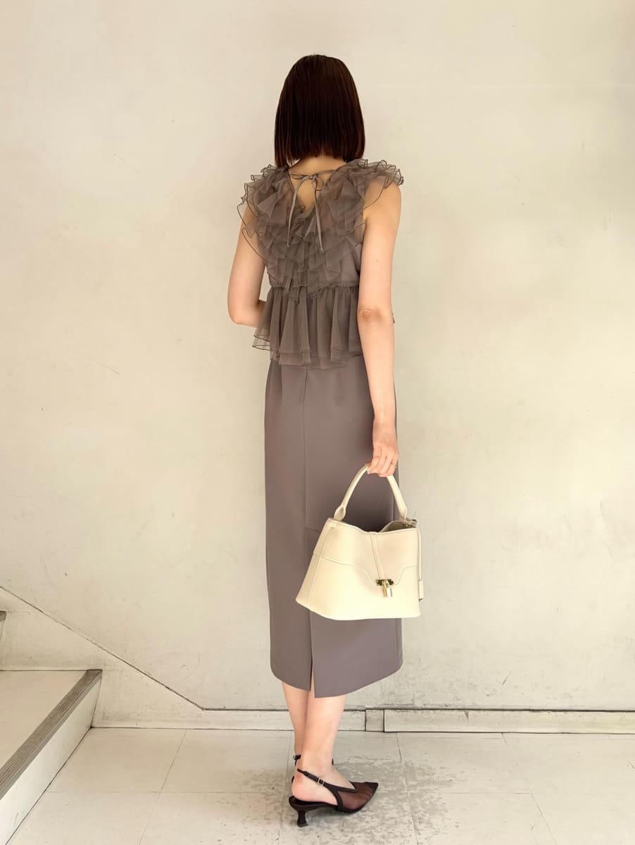ベージュ系のハンドバッグ、グレー系のドレスを着用したレディースの春コーディネートの2枚目の写真