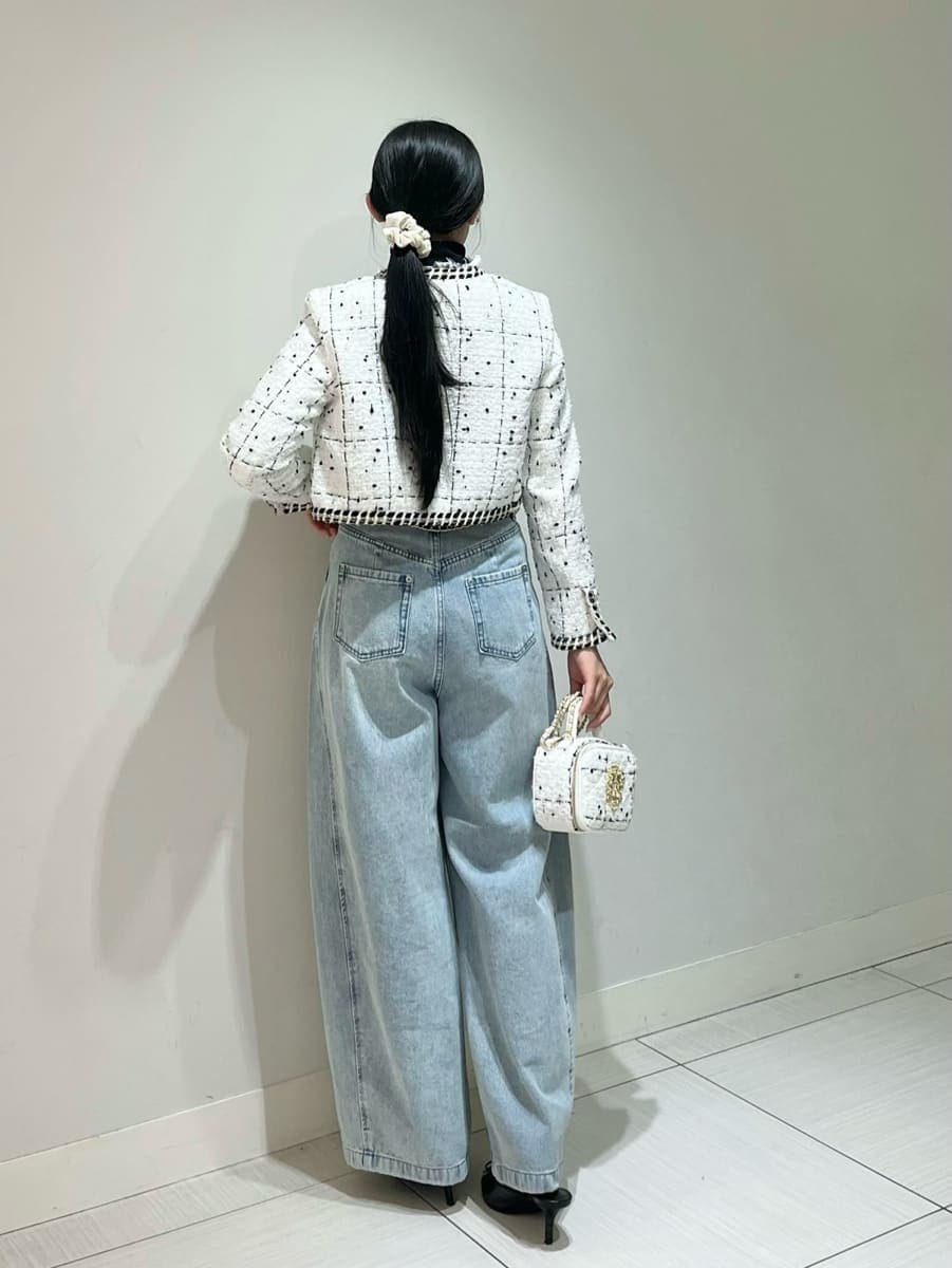 ホワイト系のノーカラージャケット、ブルー系のデニムパンツ、ブラック系のニット/セーターを着用したレディースの秋コーディネートの3枚目の写真