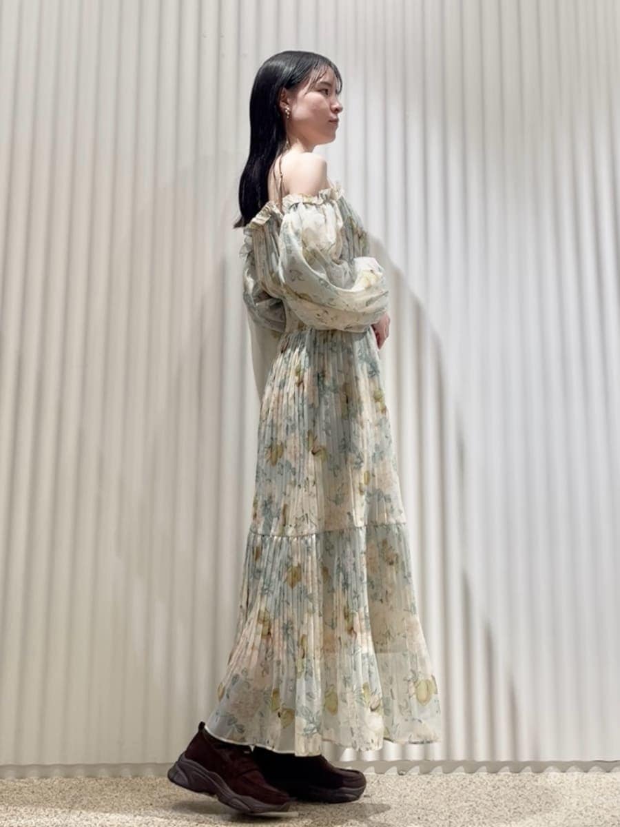 グリーン系のワンピース、ホワイト系のショルダーバッグ、ブラウン系のローファーを着用したレディースの冬コーディネートの2枚目の写真