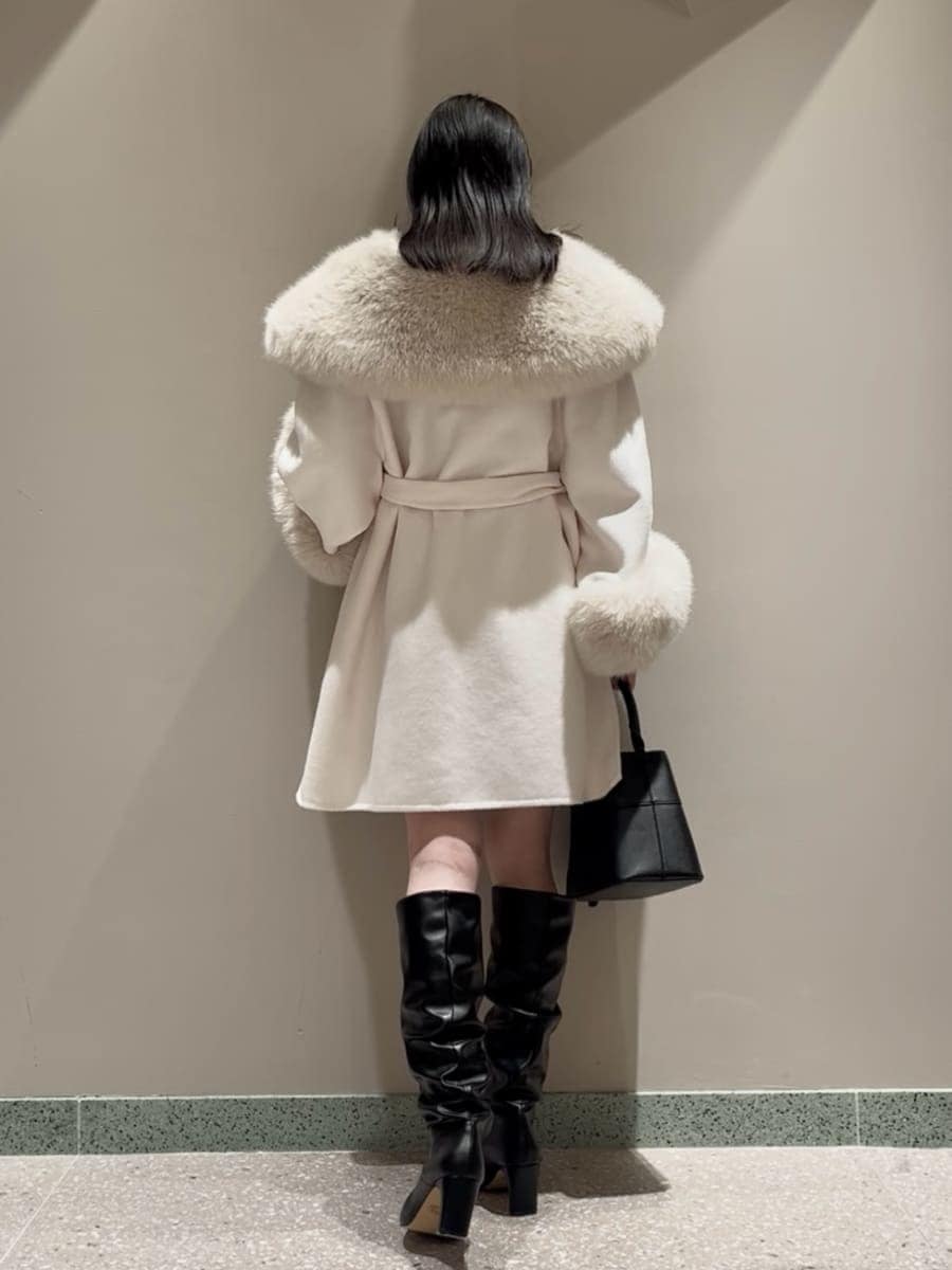 ホワイト系のチェスターコート、ブラック系のその他パンツ、ブラック系のハンドバッグを着用したレディースの冬コーディネートの3枚目の写真