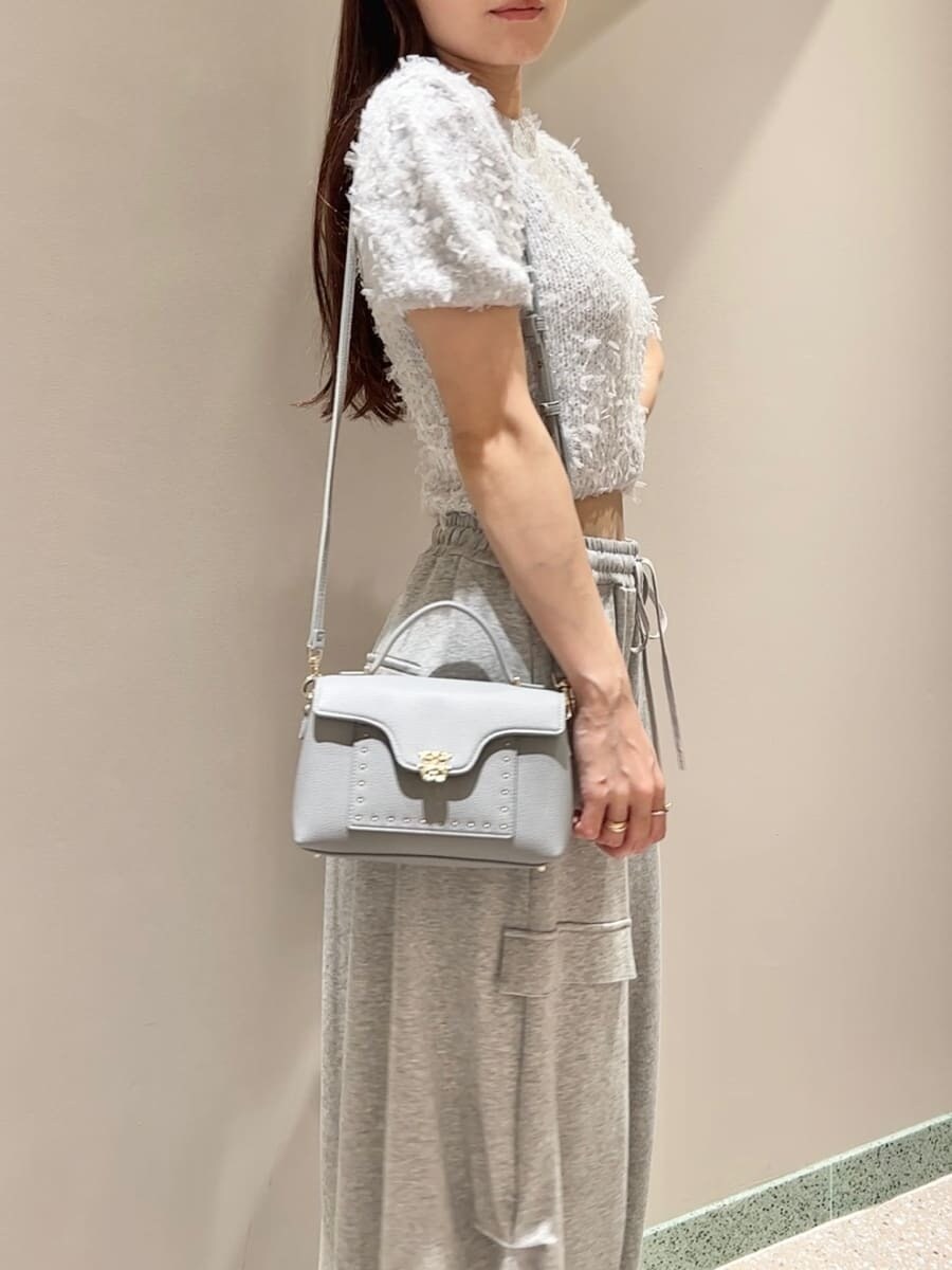 グレー系のニット/セーター、グレー系のその他パンツ、ブルー系のショルダーバッグを着用したレディースの夏コーディネートの6枚目の写真