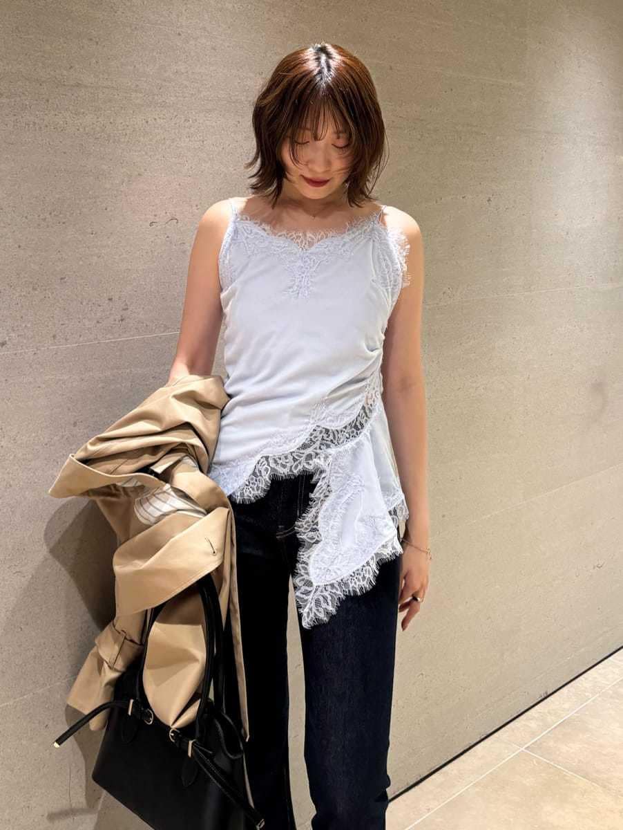 ブルー系のデニムパンツ、ベージュ系のトレンチコート、ブルー系のキャミソールを着用したレディースの秋コーディネートの8枚目の写真