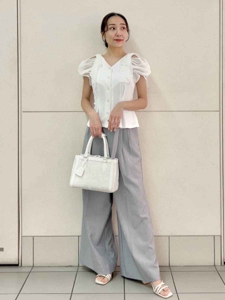 グレー系のその他パンツ、ホワイト系のTシャツ/カットソー、ホワイト系のハンドバッグを着用したレディースの夏コーディネートの2枚目の写真