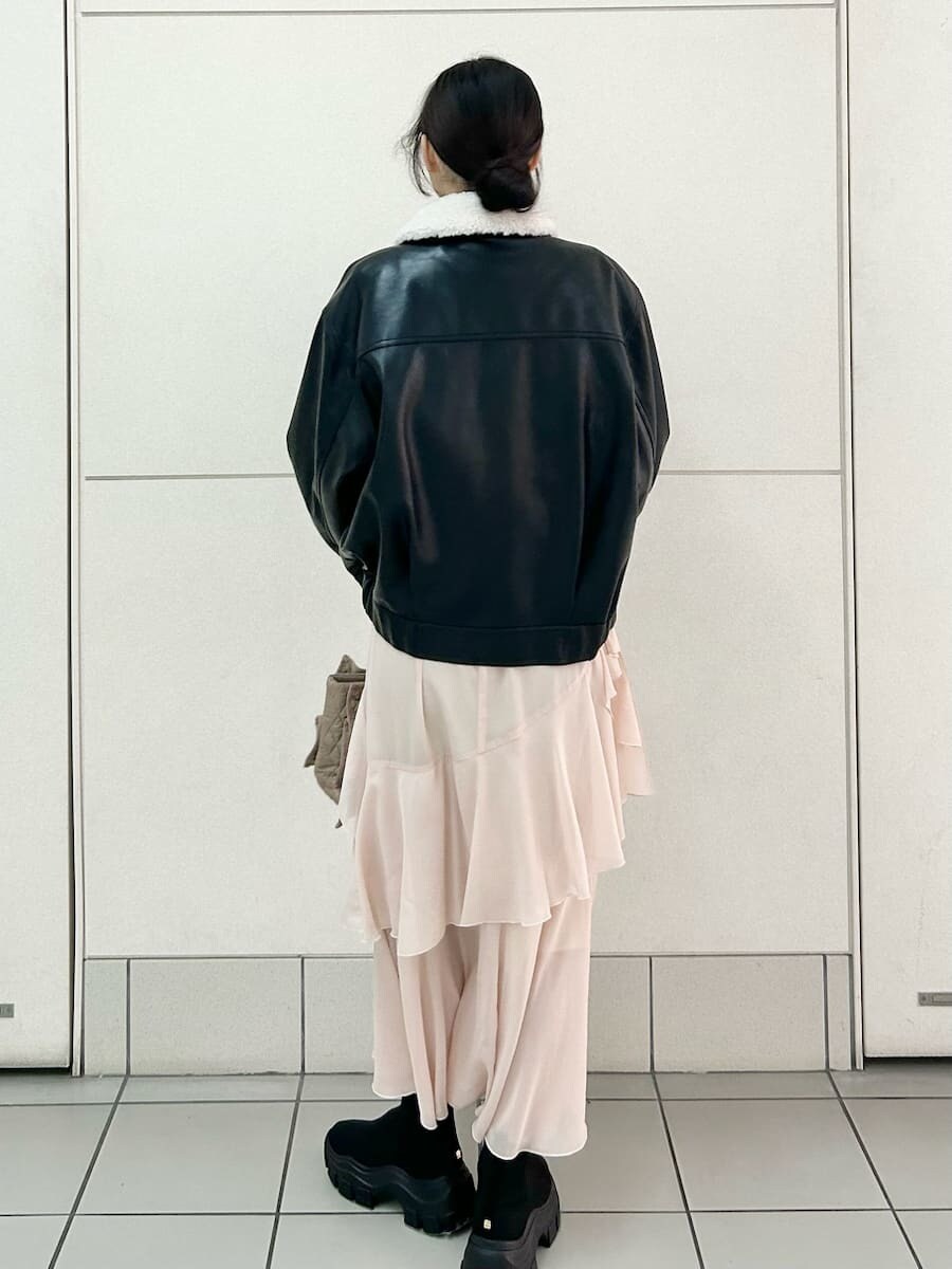 ベージュ系のハンドバッグ、ブラック系のブルゾン、ピンク系のワンピースを着用したレディースの冬コーディネートの4枚目の写真