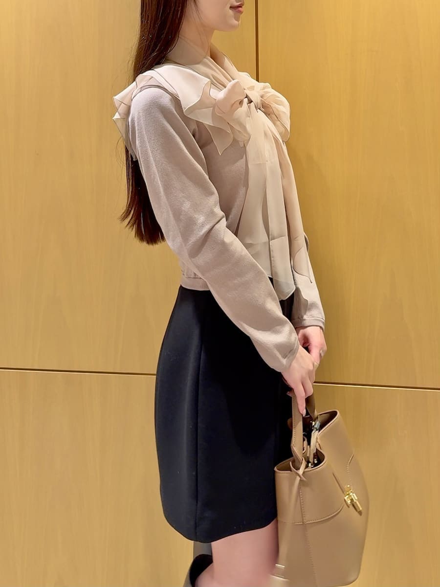 グレー系のブーツ、ピンク系のニット/セーター、ブラック系のスカートを着用したレディースの冬コーディネートの6枚目の写真