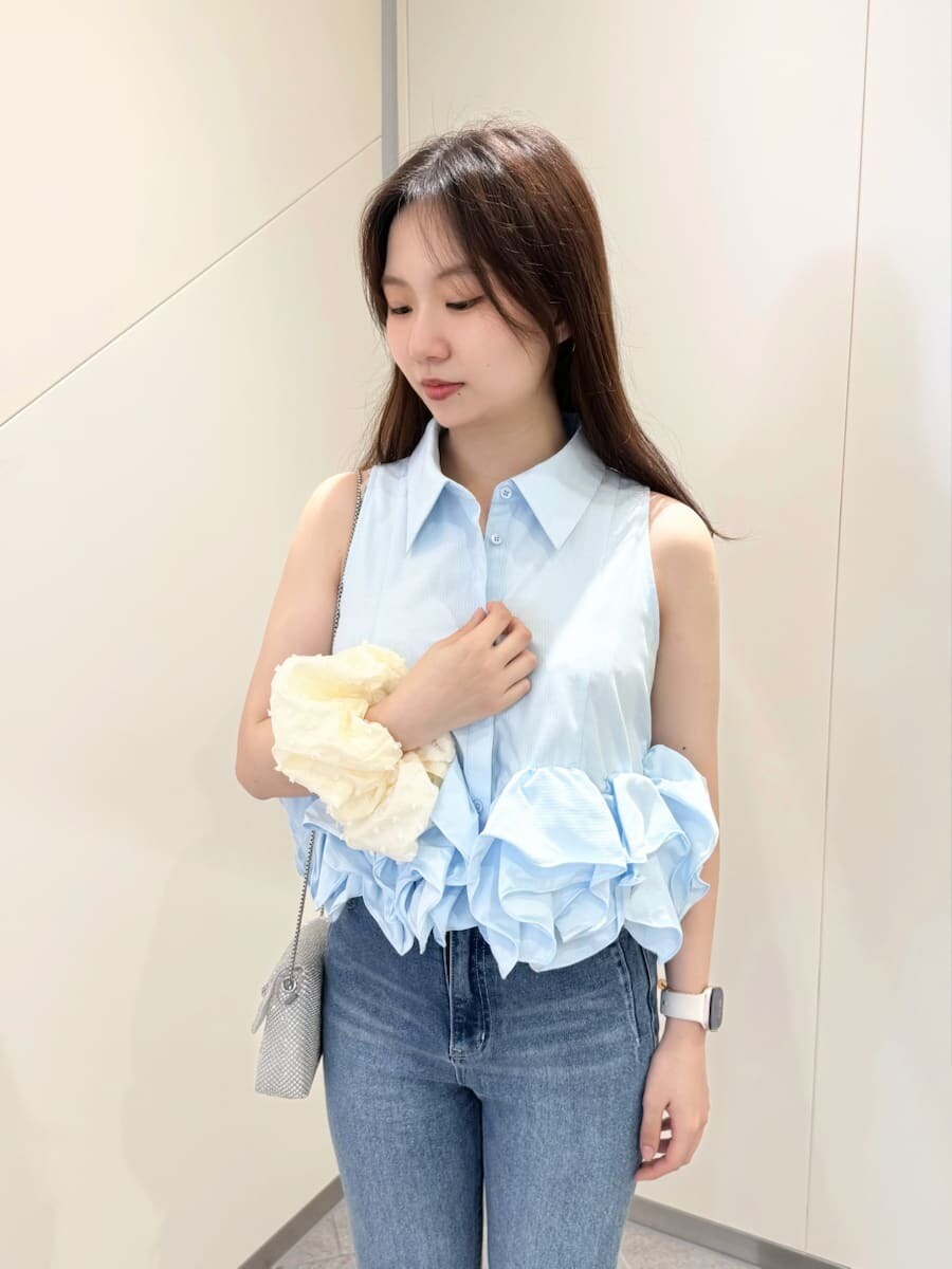 ブルー系のシャツ/ブラウス、ブラック系のサンダル、ブルー系のデニムパンツを着用したレディースの春コーディネートの6枚目の写真