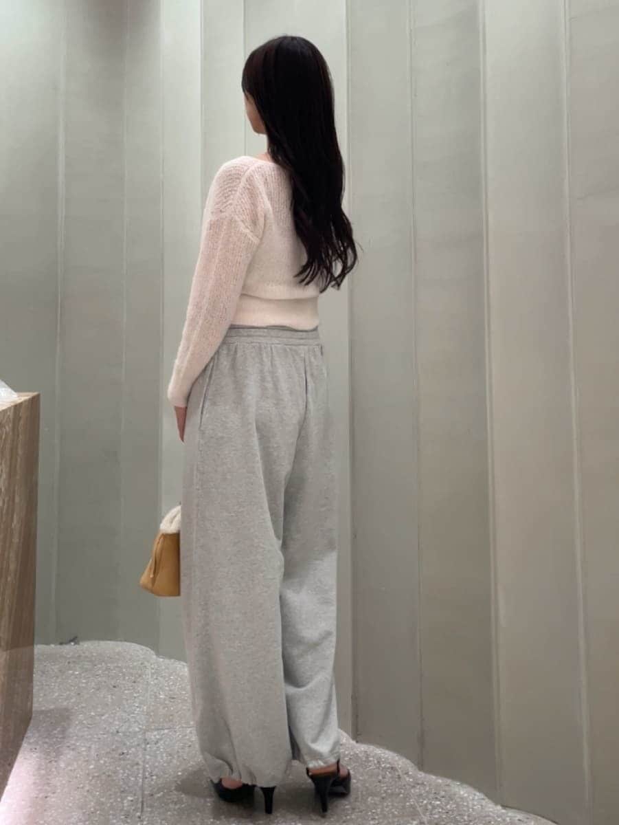 グレー系のその他パンツ、ピンク系のカーディガン/ボレロ、ブラック系のパンプスを着用したレディースの秋コーディネートの6枚目の写真