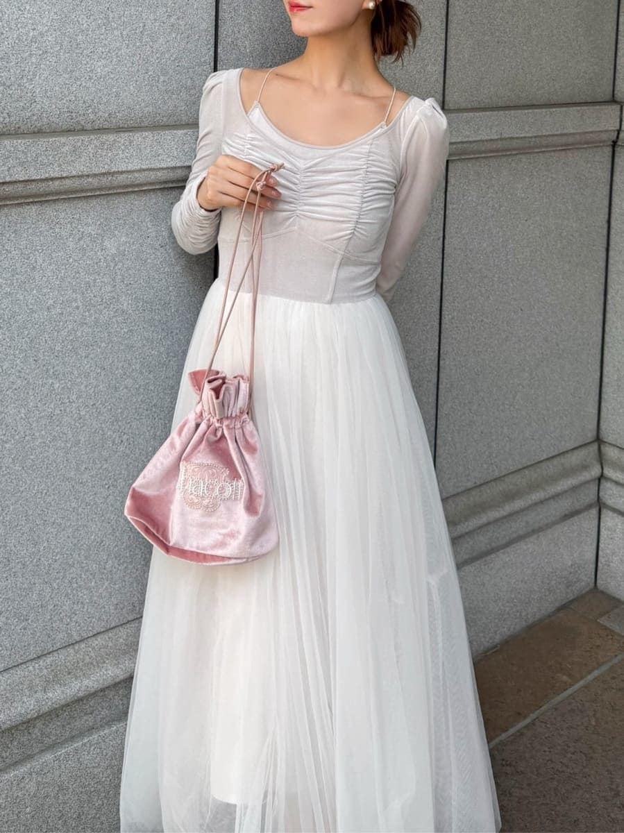 ホワイト系のワンピース、ピンク系のハンドバッグ、ブラック系のパンプスを着用したレディースの夏コーディネートの3枚目の写真