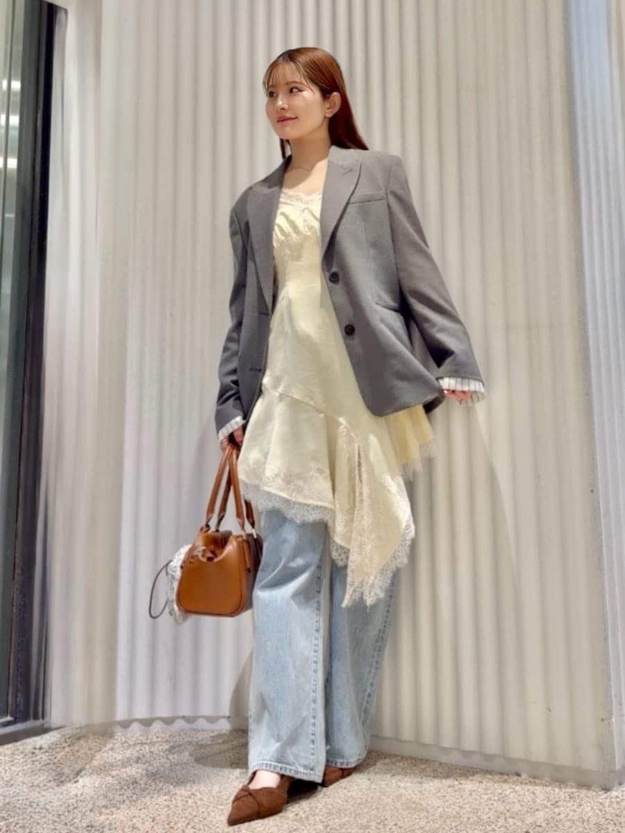 グレー系のテーラードジャケット、ブルー系のデニムパンツ、イエロー系のキャミソールを着用したレディースの春コーディネートの5枚目の写真
