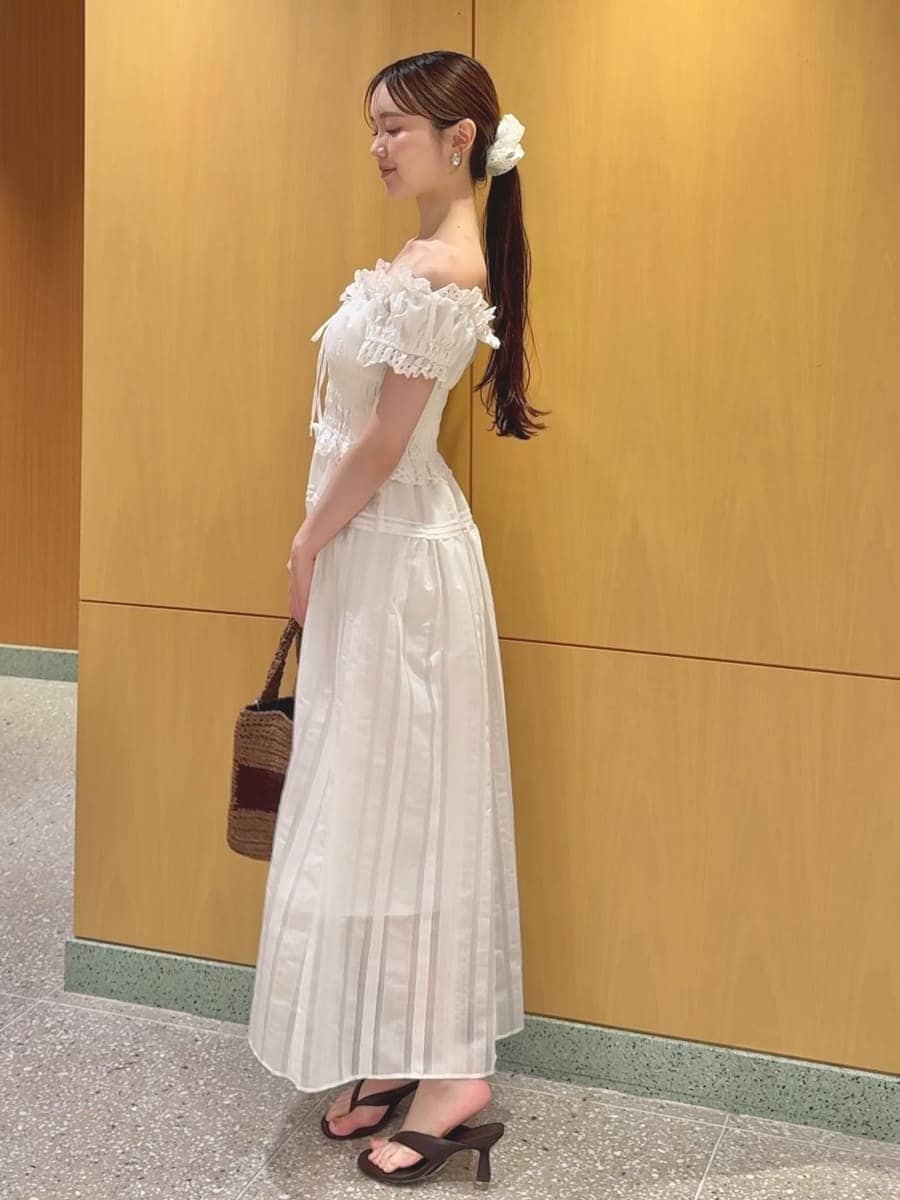 ホワイト系のワンピース、ブラウン系のサンダル、ブラウン系のトートバッグを着用したレディースの夏コーディネートの2枚目の写真