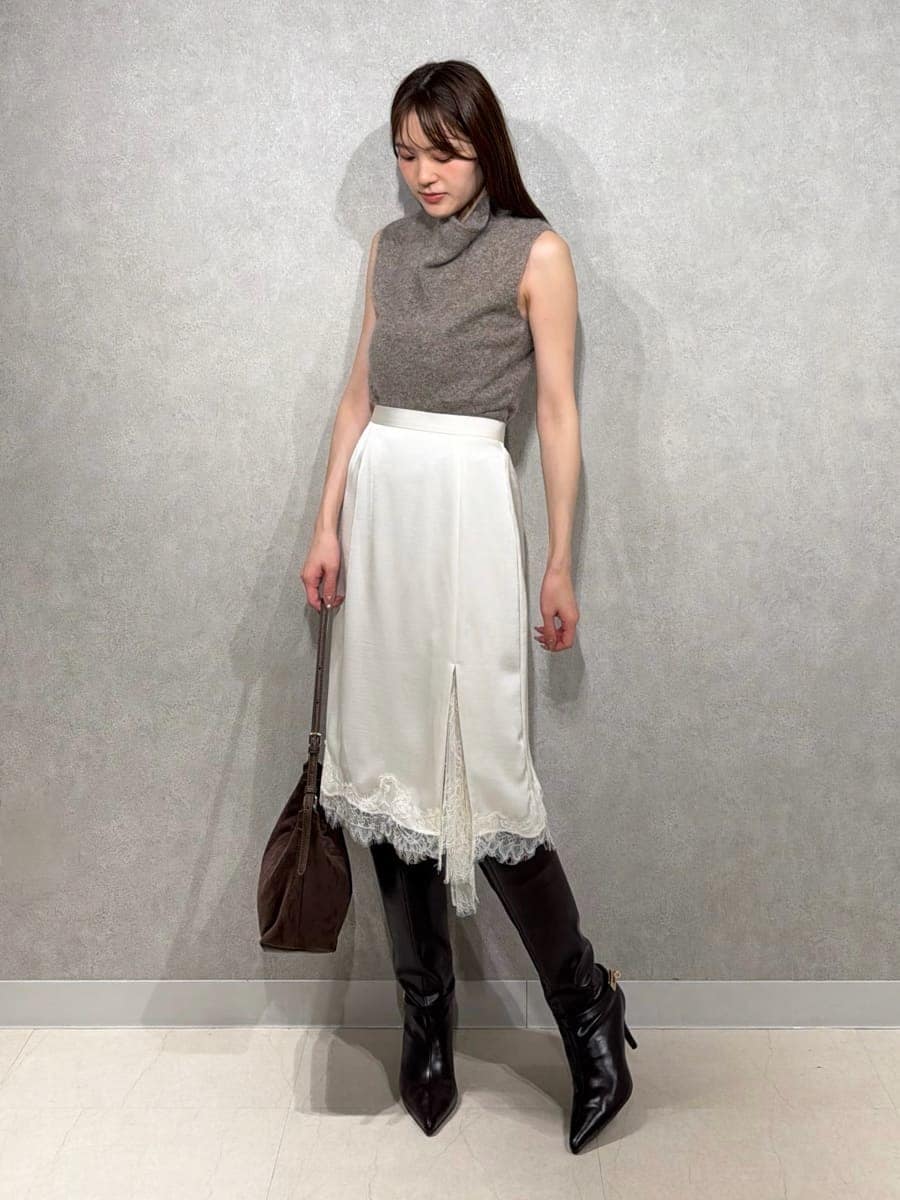 ベージュ系のトレンチコート、ホワイト系のスカート、ブラウン系のTシャツ/カットソーを着用したレディースの秋コーディネートの6枚目の写真