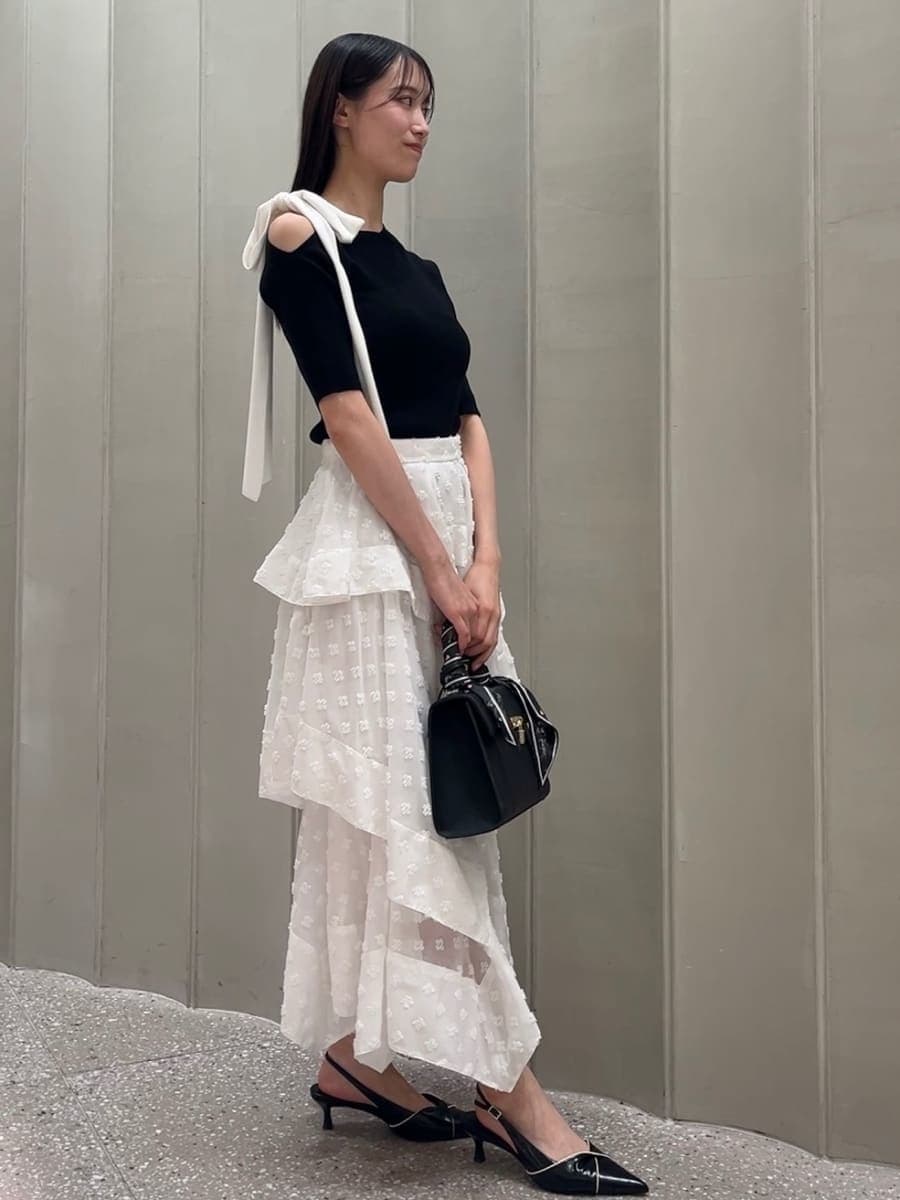 その他のスカート、ブラック系のパンプス、ブラック系のハンドバッグを着用したレディースの春コーディネートの5枚目の写真