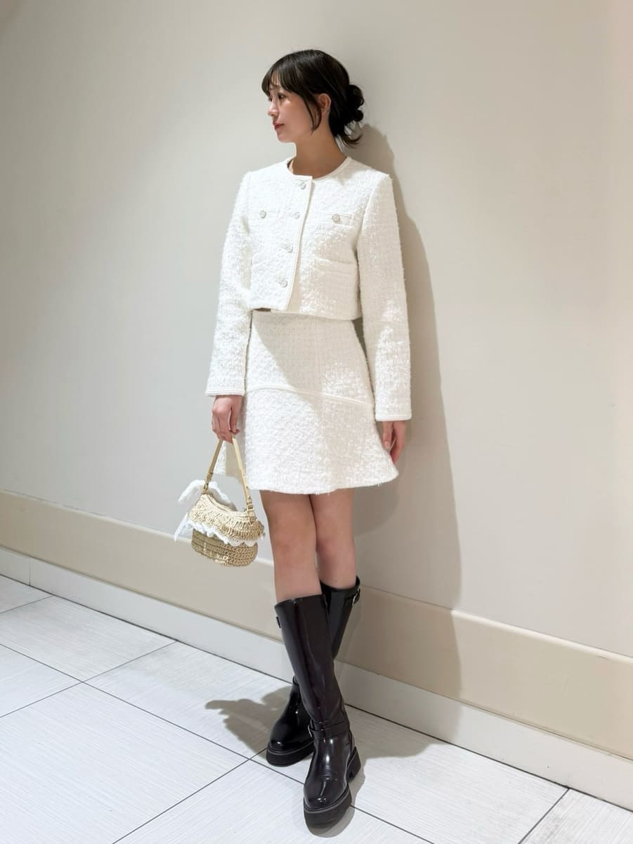 ブラウン系のブーツ、ホワイト系のノーカラージャケット、ホワイト系のスカートを着用したレディースの冬コーディネートの4枚目の写真