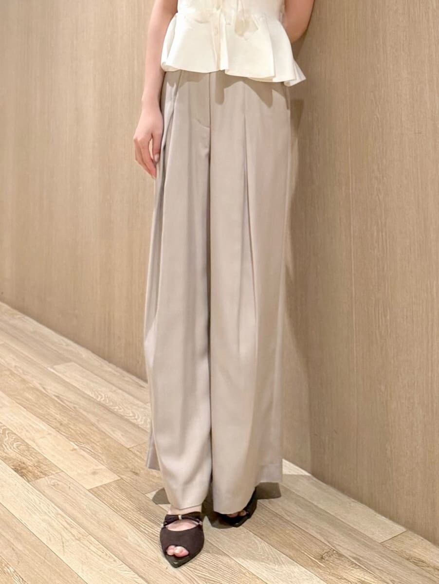 ベージュ系のその他パンツ、ホワイト系のニット/セーター、ブラウン系のサンダルを着用したレディースの夏コーディネートの5枚目の写真