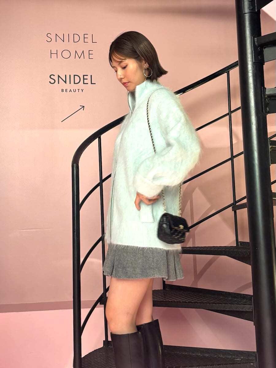 グリーン系のブルゾン、グレー系のスカート、ブラック系のショルダーバッグを着用したレディースの秋コーディネートの2枚目の写真