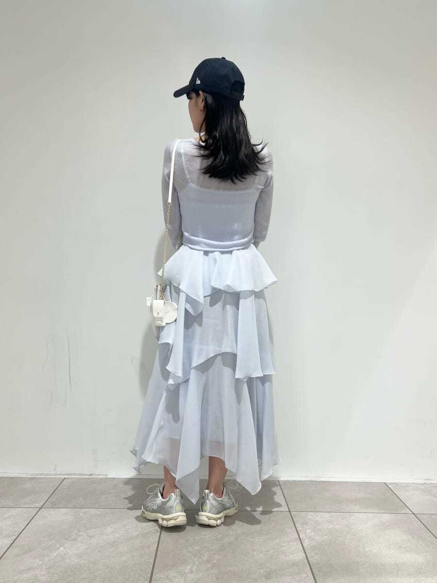 ブルー系のワンピース、ホワイト系のショルダーバッグ、シルバー系のスニーカーを着用したレディースの冬コーディネートの3枚目の写真