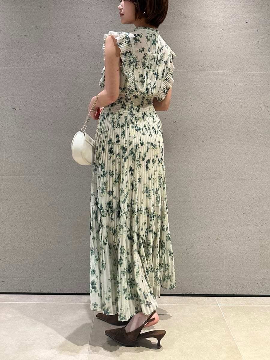 グリーン系のワンピース、ホワイト系のカーディガン/ボレロ、ブラウン系のパンプスを着用したレディースの冬コーディネートの8枚目の写真