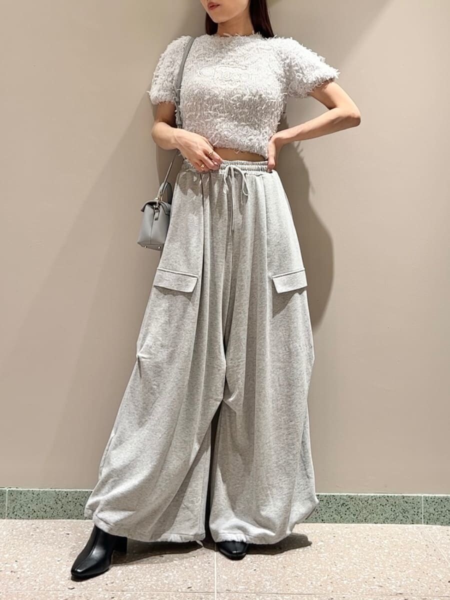 グレー系のニット/セーター、グレー系のその他パンツ、ブルー系のショルダーバッグを着用したレディースの夏コーディネートの4枚目の写真