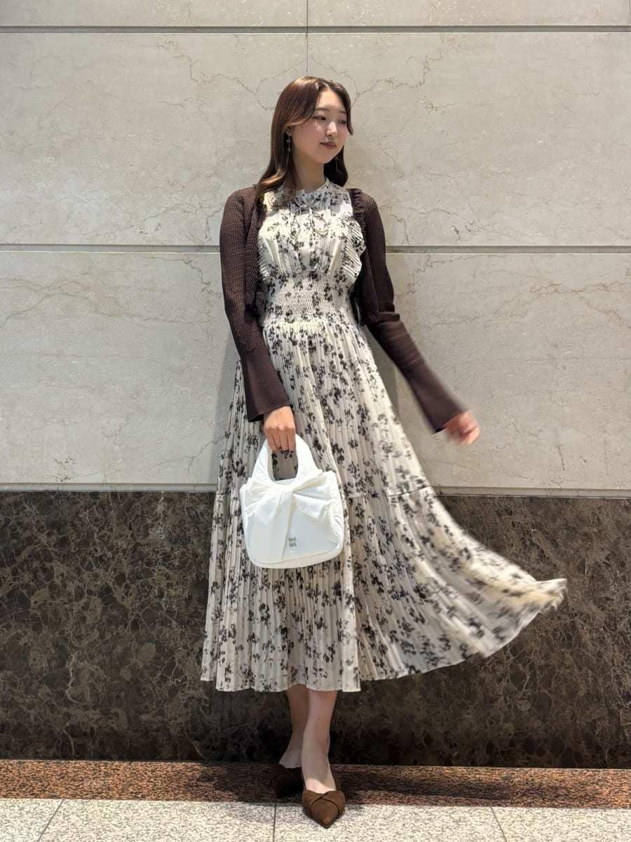 ベージュ系のワンピース、ホワイト系のカーディガン/ボレロ、ブラウン系のパンプスを着用したレディースの冬コーディネートの3枚目の写真