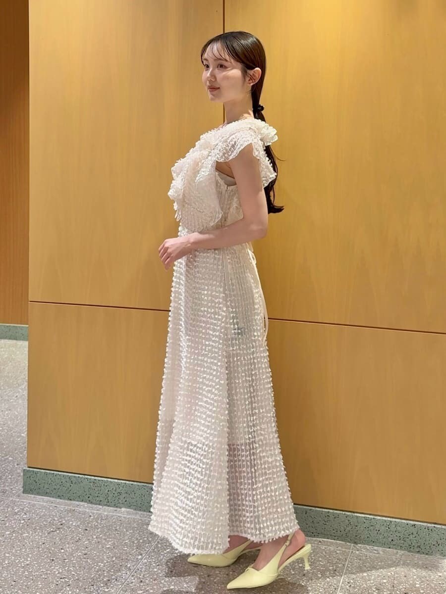 ホワイト系のドレス、イエロー系のパンプス、イエロー系のショルダーバッグを着用したレディースの春コーディネートの2枚目の写真