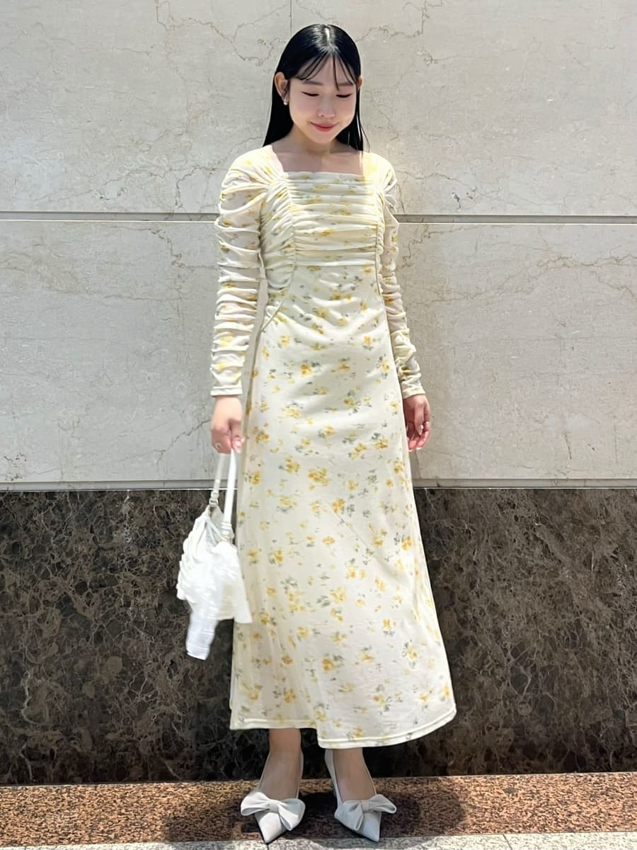 イエロー系のワンピース、その他のピアス（両耳用）を着用したレディースの冬コーディネートの2枚目の写真