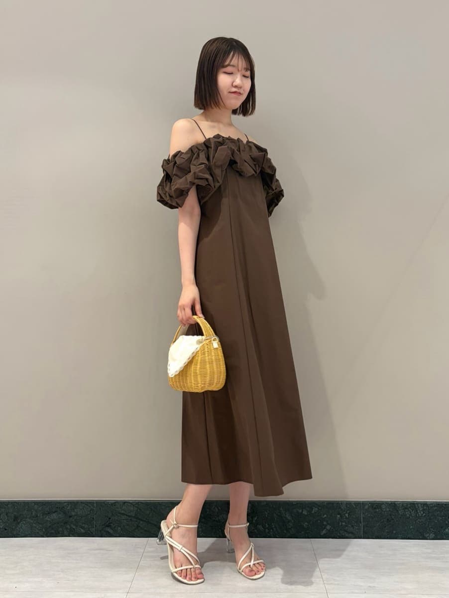 ホワイト系のサンダル、ホワイト系のかごバッグ、ブラウン系のワンピースを着用したレディースの夏コーディネートの4枚目の写真