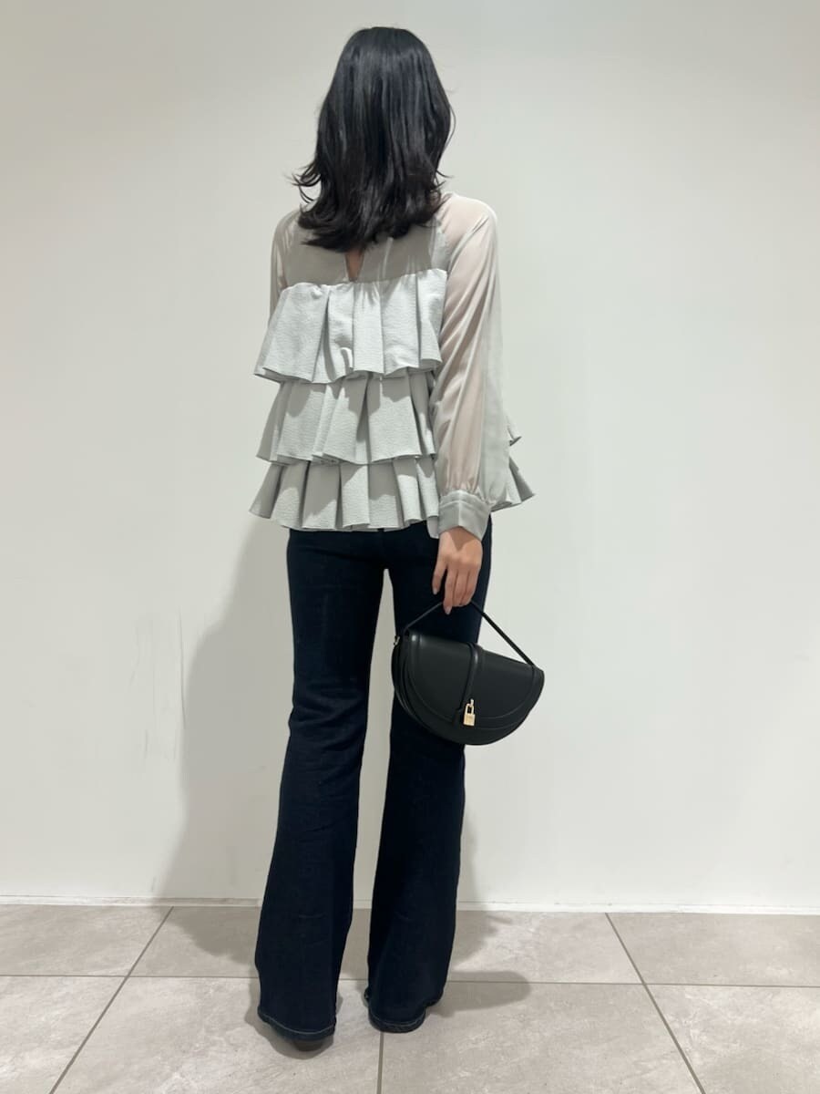 ブラック系のハンドバッグ、ブルー系のその他パンツ、グリーン系のドレスを着用したレディースの冬コーディネートの3枚目の写真