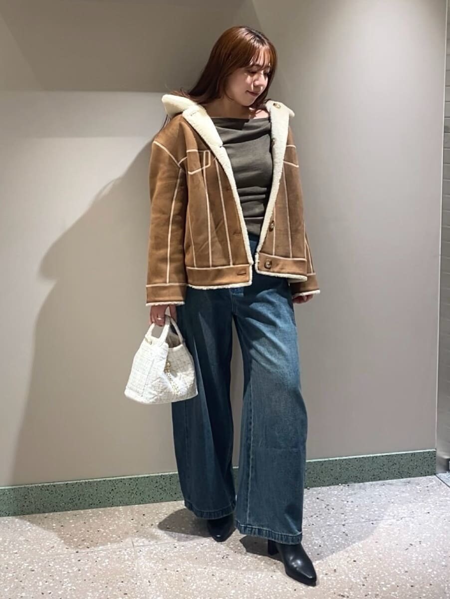 ブルー系のデニムパンツ、ブラウン系のニット/セーター、ブラック系のブーツを着用したレディースの秋コーディネートの2枚目の写真