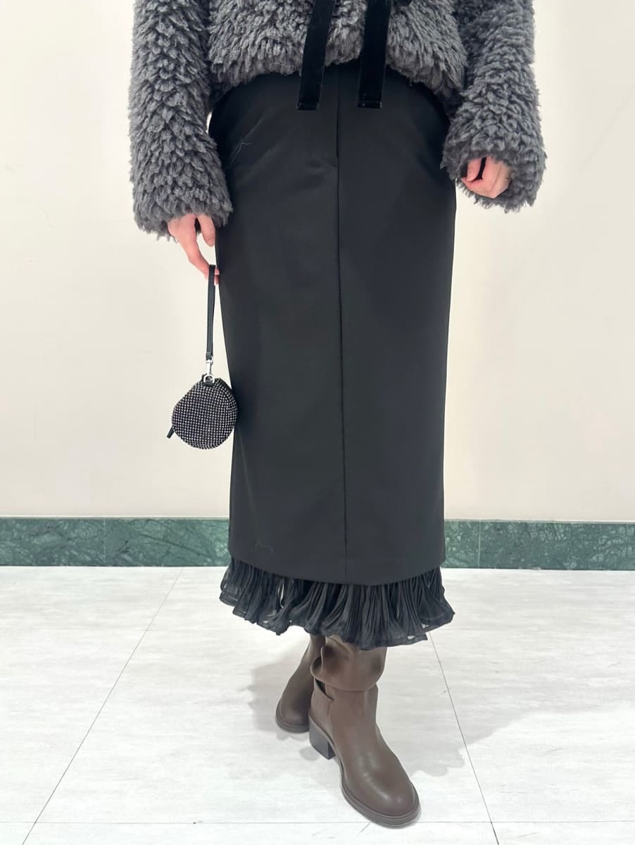 グレー系のムートンコート、ブラック系のスカートを着用したレディースの秋コーディネートの3枚目の写真