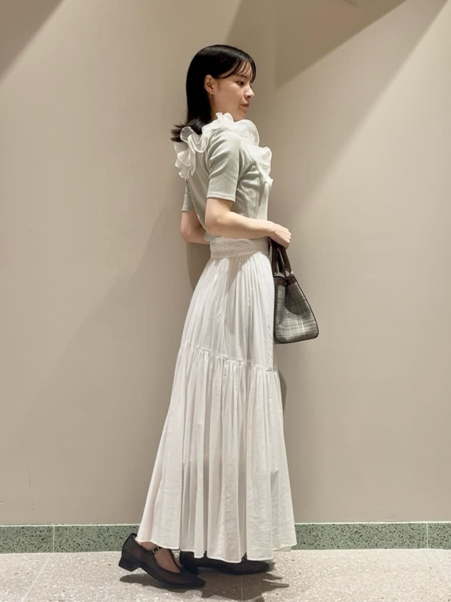 グリーン系のTシャツ/カットソー、ホワイト系のスカート、ブラウン系のハンドバッグを着用したレディースの夏コーディネートの2枚目の写真