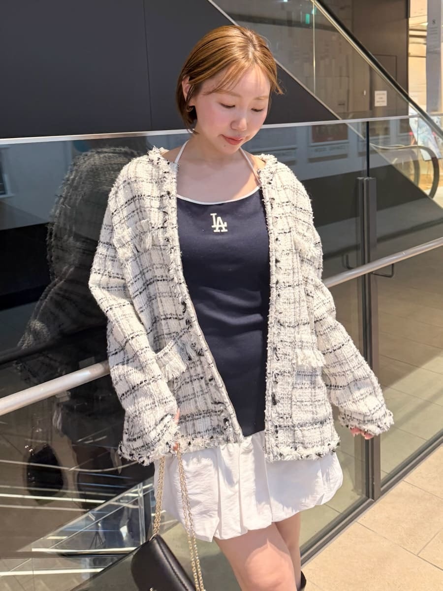 ホワイト系のノーカラージャケット、ブルー系のワンピース、ブラック系のショルダーバッグを着用したレディースの春コーディネートの2枚目の写真