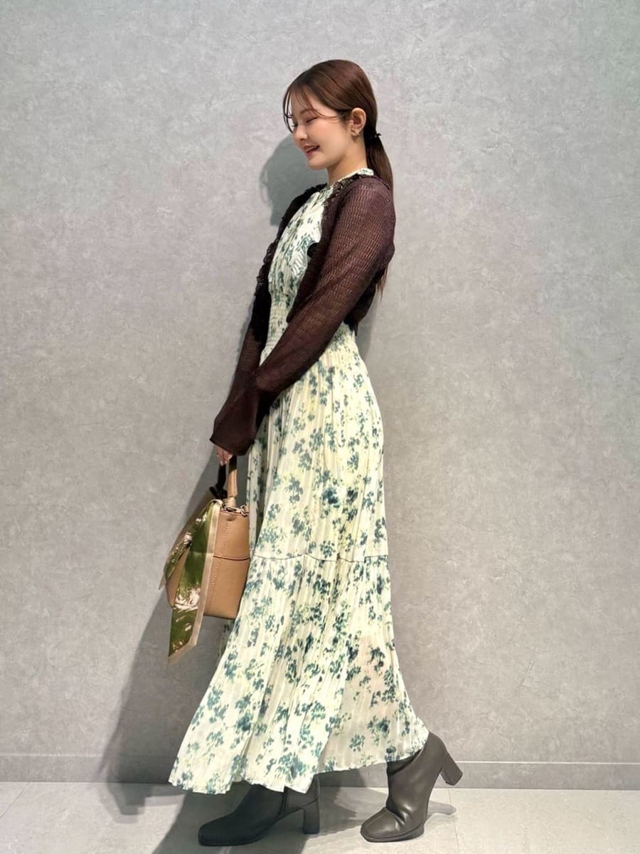 イエロー系のハンドバッグ、グリーン系のワンピース、ブラウン系のカーディガン/ボレロを着用したレディースの冬コーディネートの2枚目の写真