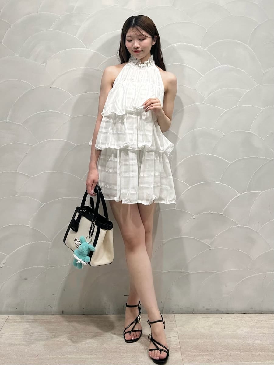 ホワイト系のワンピース、ブルー系のカーディガン/ボレロ、ホワイト系のハンドバッグを着用したレディースの春コーディネートの6枚目の写真
