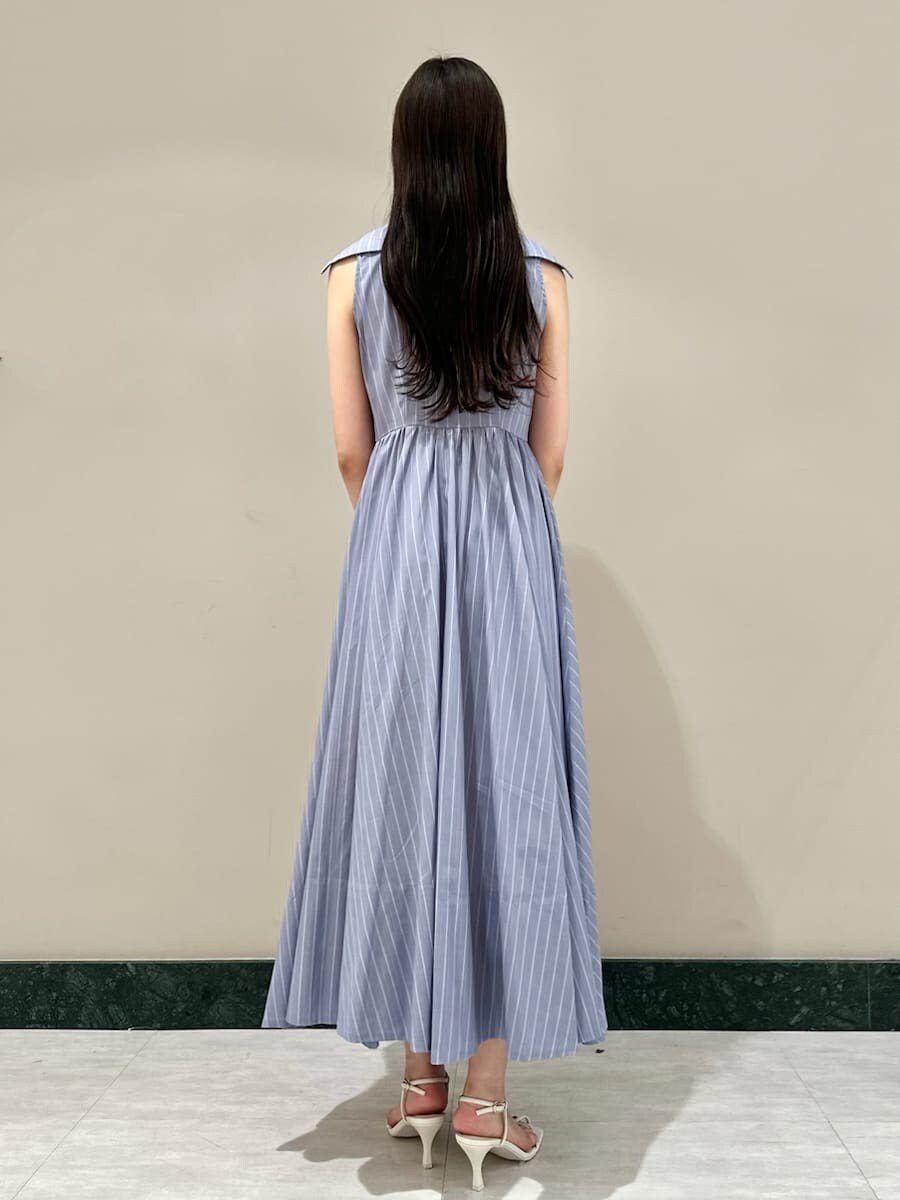 ブルー系のワンピース、ホワイト系のサンダル、ホワイト系のかごバッグを着用したレディースの夏コーディネートの3枚目の写真